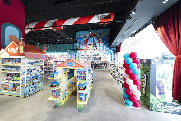 Zona infantil con expositores de Bluey y Peppa Pig y columna de globos en la tienda de juguetes de Puerto Venecia Abracadabra