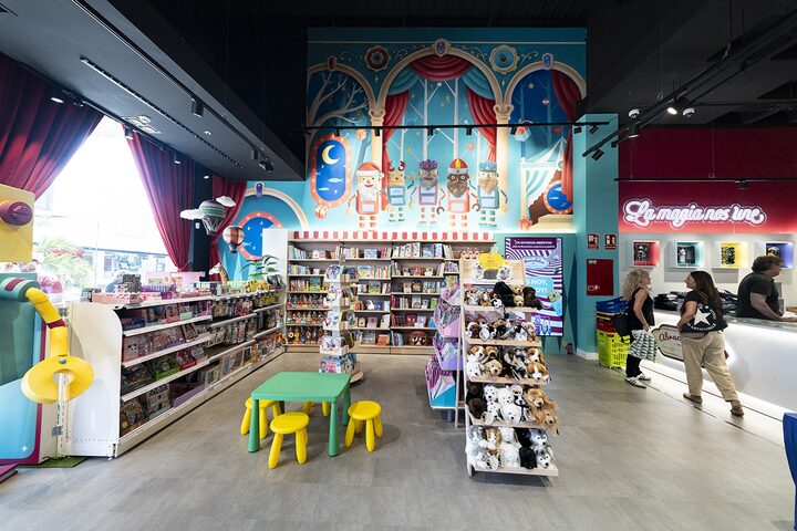 &Aacute;rea de libros y peluches con mural decorativo y zona de lectura infantil en la jugueter&iacute;a de Puerto Venecia Abracadabra